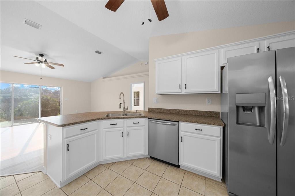 12205 Southeast 100th Court Belleview, FL 34420 - Photo 40 of 73 a kitchen with white cabinets and appliances