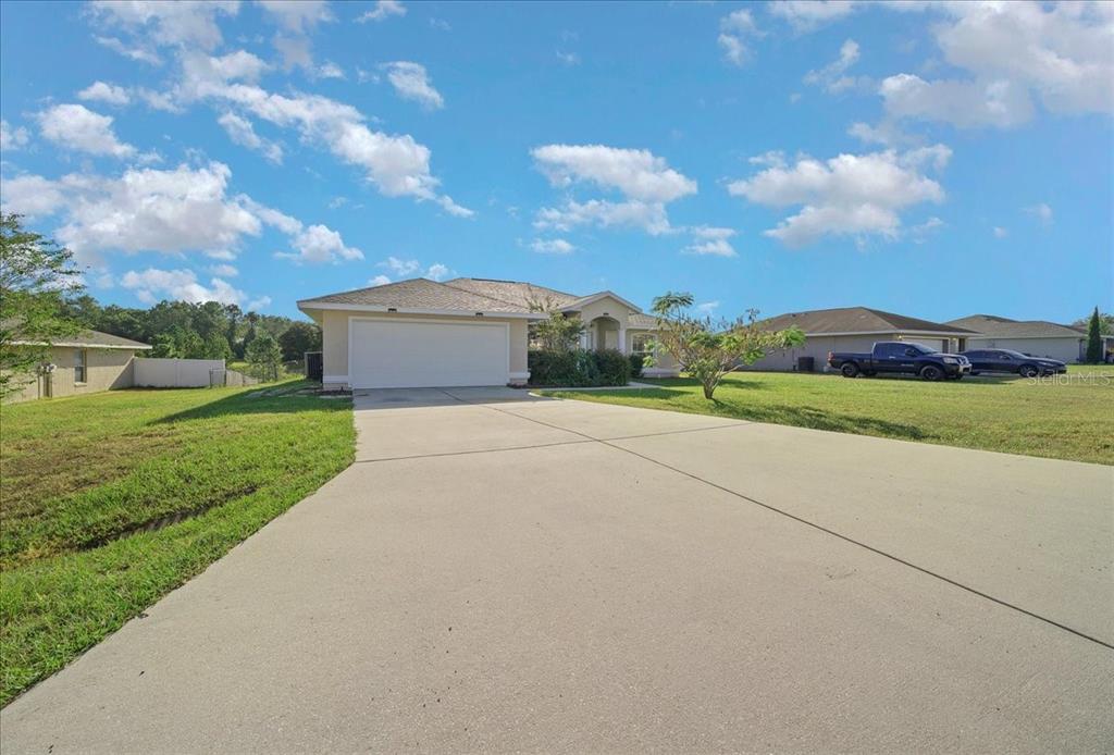 12205 Southeast 100th Court Belleview, FL 34420 - Photo 7 of 73 a view of a big house with a big yard and large trees