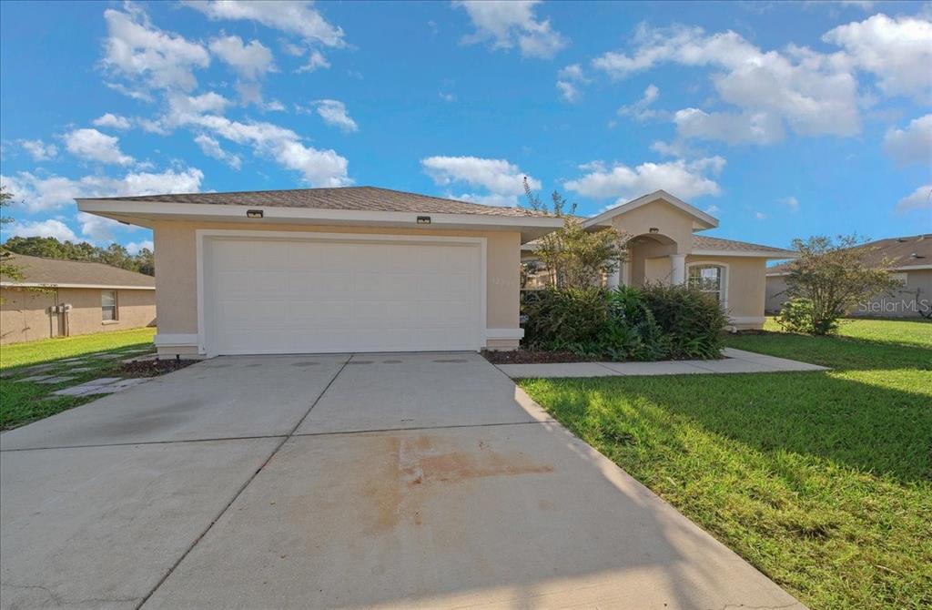 12205 Southeast 100th Court Belleview, FL 34420 - Photo 9 of 73 a view of a white house with a yard