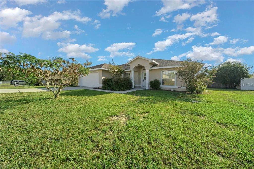 12205 Southeast 100th Court Belleview, FL 34420 - Photo 10 of 73 a view of a house with a big yard and a large tree