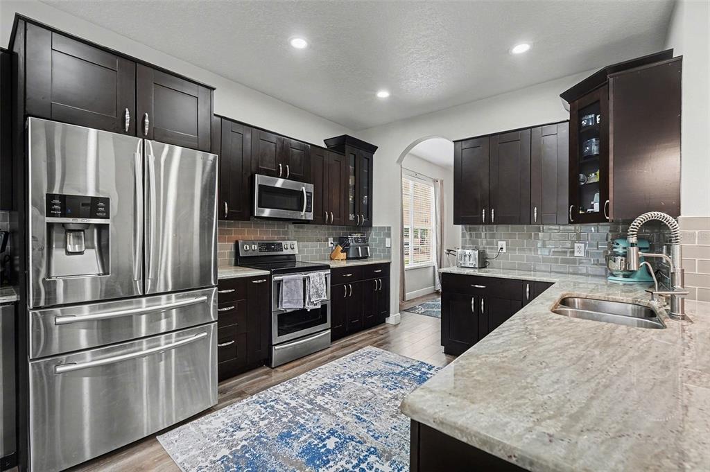 1952 Fruitridge Street Brandon, FL 33510 - Photo 16 of 39 a kitchen with granite countertop stainless steel appliances and wooden cabinets