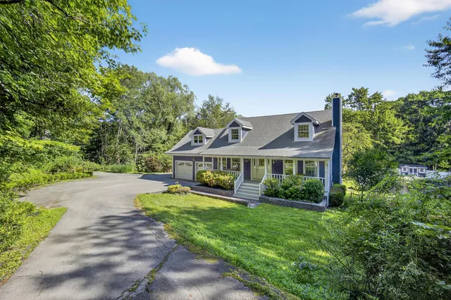 a view of a house with a big yard plants and large trees
