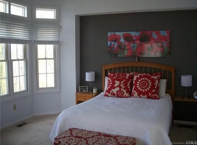 a bed sitting in a bedroom next to a window