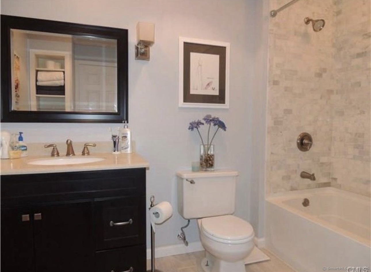 926 Quinnipiac Avenue, Unit 1 New Haven, CT 06513 - Photo 8 of 10 a bathroom with a toilet sink vanity tub and mirror