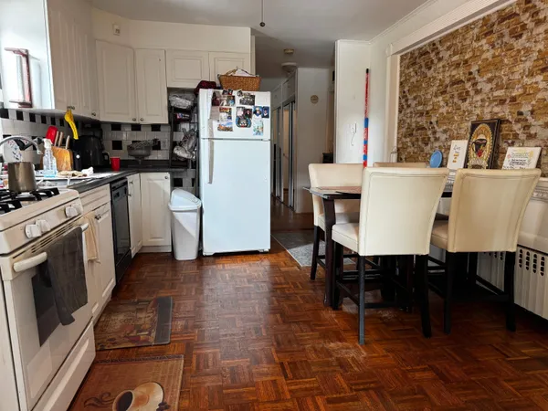 a kitchen with a table chairs refrigerator and microwave