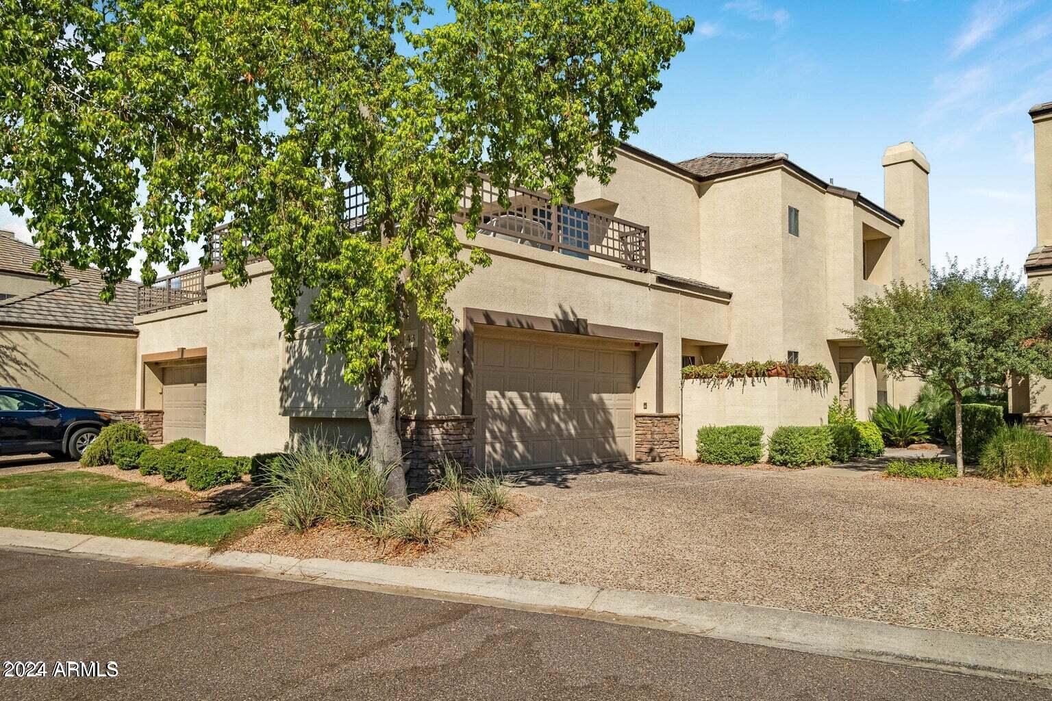 7272 East Gainey Ranch Road, Unit 43 Scottsdale, AZ 85258 - Photo 2 of 40 a front view of a house with a yard and garage
