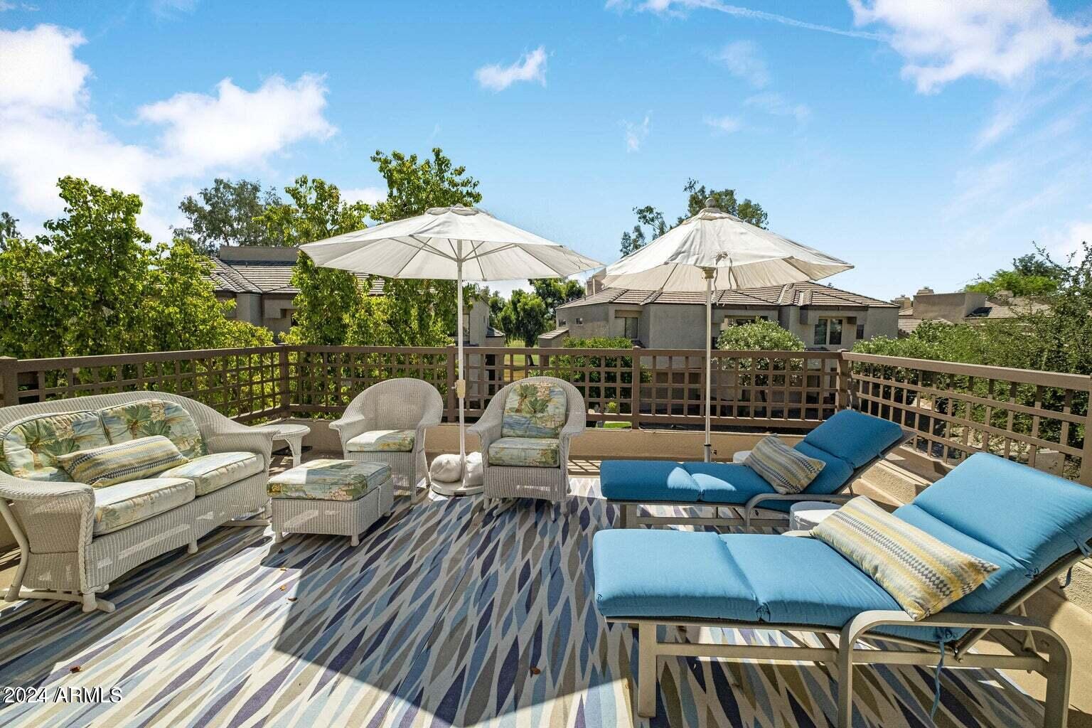 7272 East Gainey Ranch Road, Unit 43 Scottsdale, AZ 85258 - Photo 22 of 40 a view of a roof deck with couches chairs with wooden floor