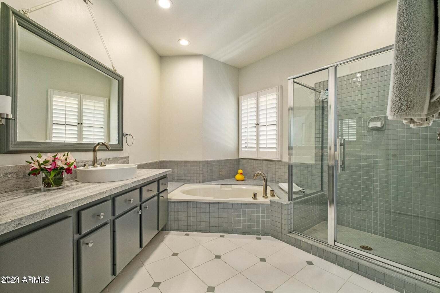 7272 East Gainey Ranch Road, Unit 43 Scottsdale, AZ 85258 - Photo 23 of 40 a bathroom with a tub sink mirror and a shower