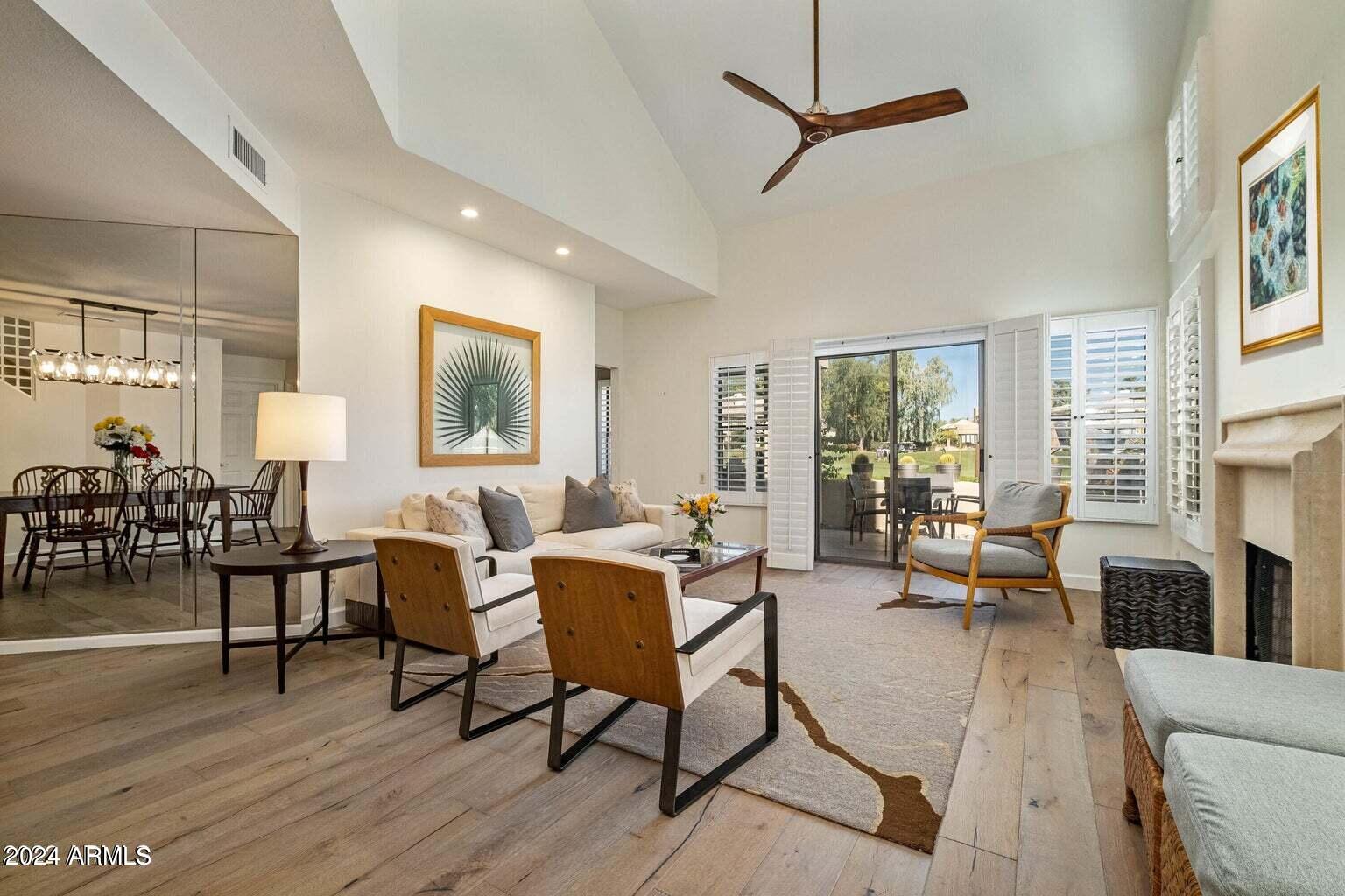 7272 East Gainey Ranch Road, Unit 43 Scottsdale, AZ 85258 - Photo 5 of 40 a living room with furniture a dining table and a large window