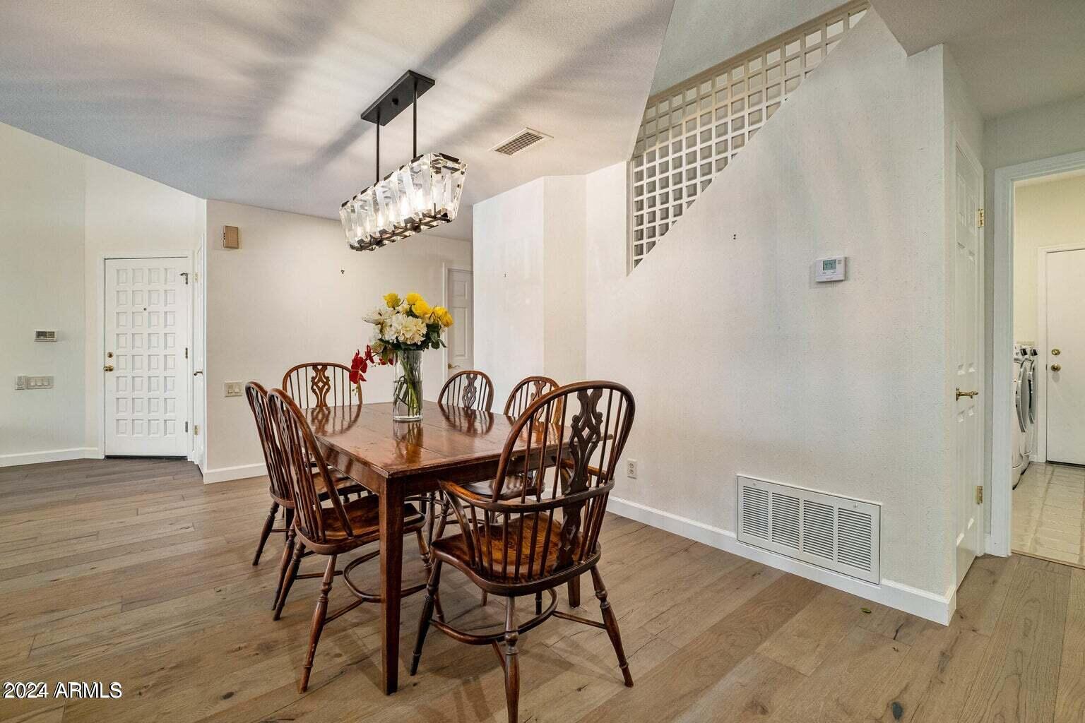 7272 East Gainey Ranch Road, Unit 43 Scottsdale, AZ 85258 - Photo 7 of 40 a view of a dining room with furniture wooden floor and chandelier