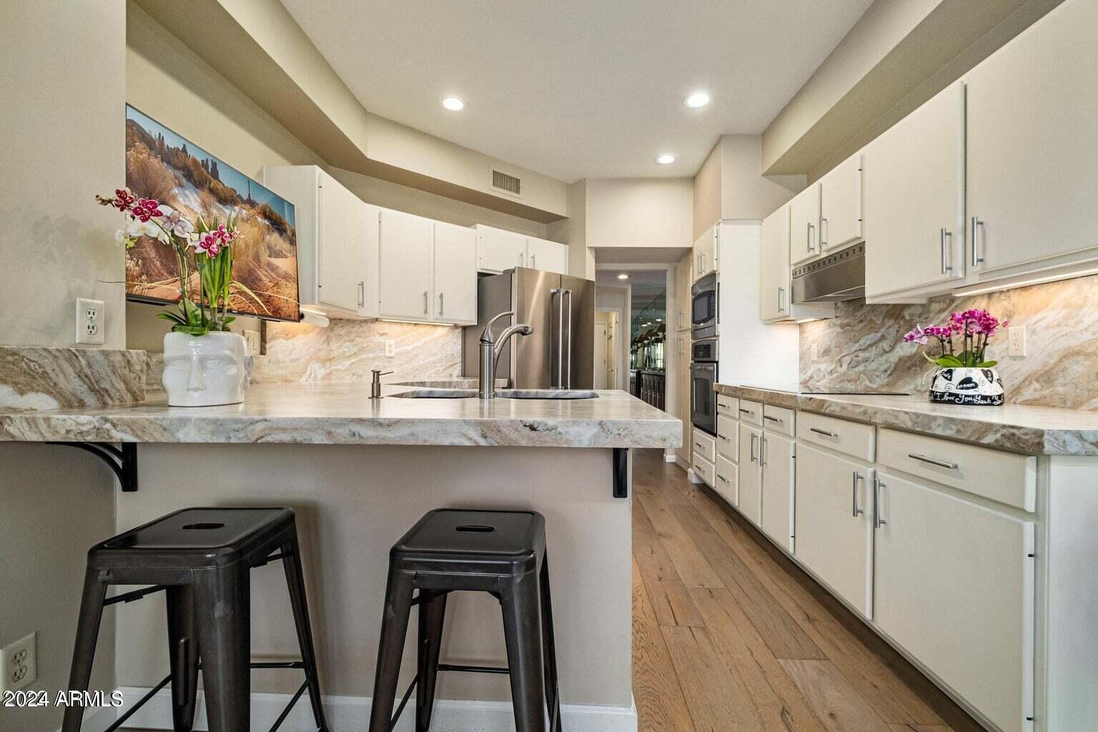 7272 East Gainey Ranch Road, Unit 43 Scottsdale, AZ 85258 - Photo 10 of 40 a kitchen with chairs and cabinets