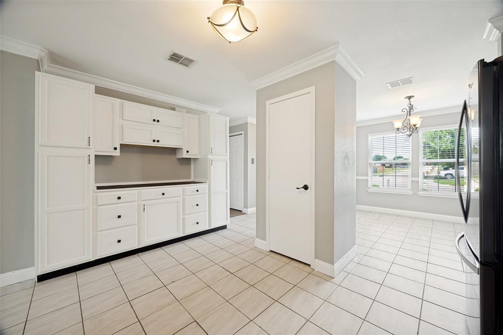 1601 Elm Street Anna, TX 75409 - Photo 5 of 25 a kitchen with white cabinets a stove a sink and a refrigerator with wooden floor