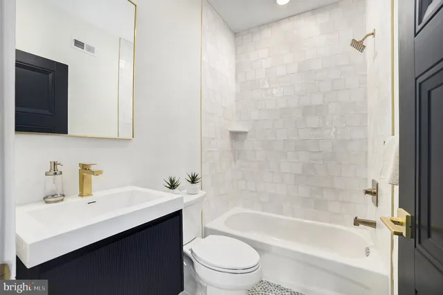 a bathroom with a sink a toilet a mirror and shower