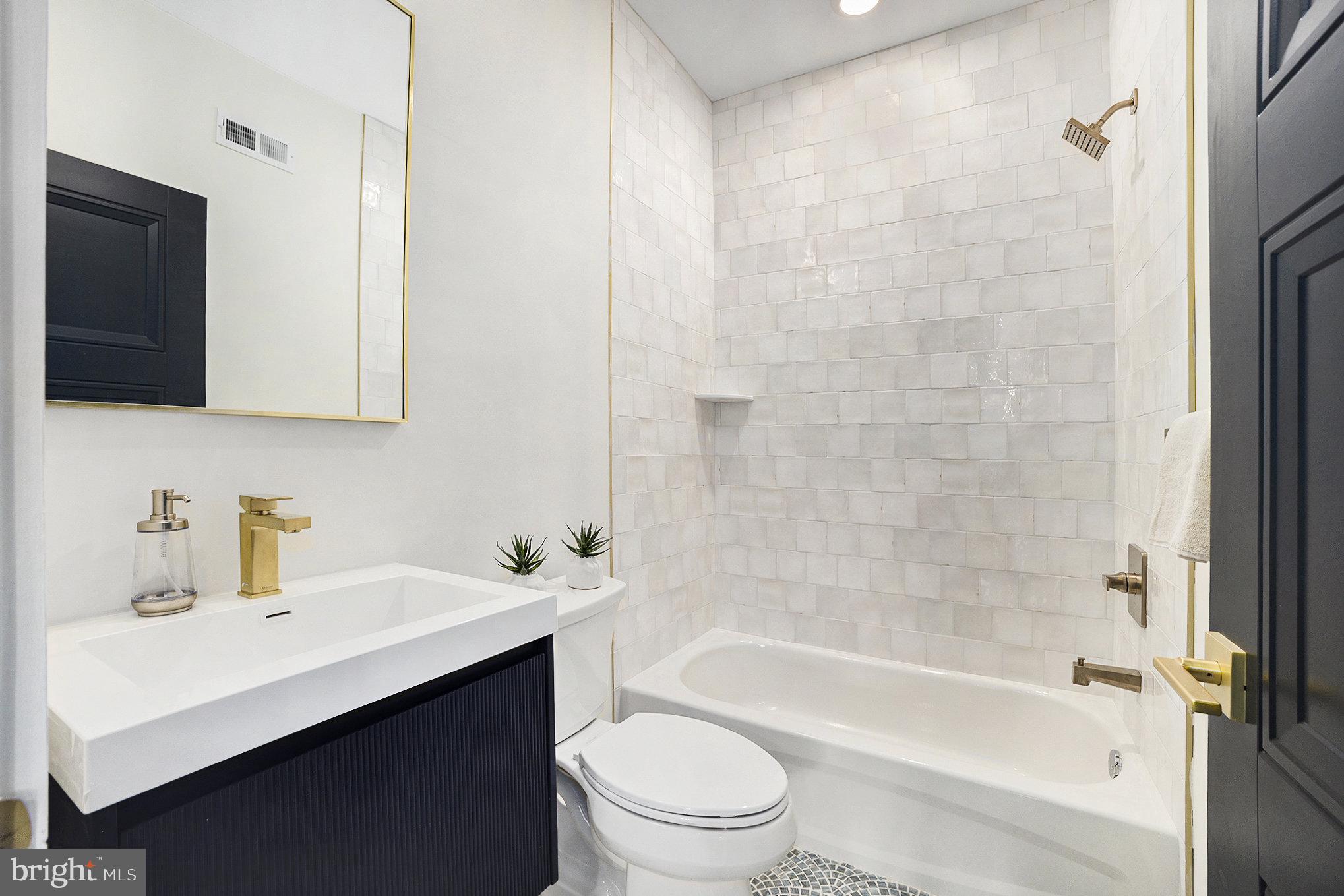 7519 Ridge Avenue, Unit 203 Philadelphia, PA 19128 - Photo 15 of 26 a bathroom with a sink a toilet a mirror and shower