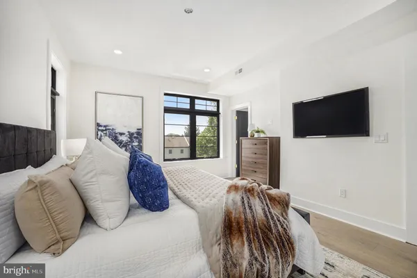 a spacious bedroom with a bed and a flat screen tv