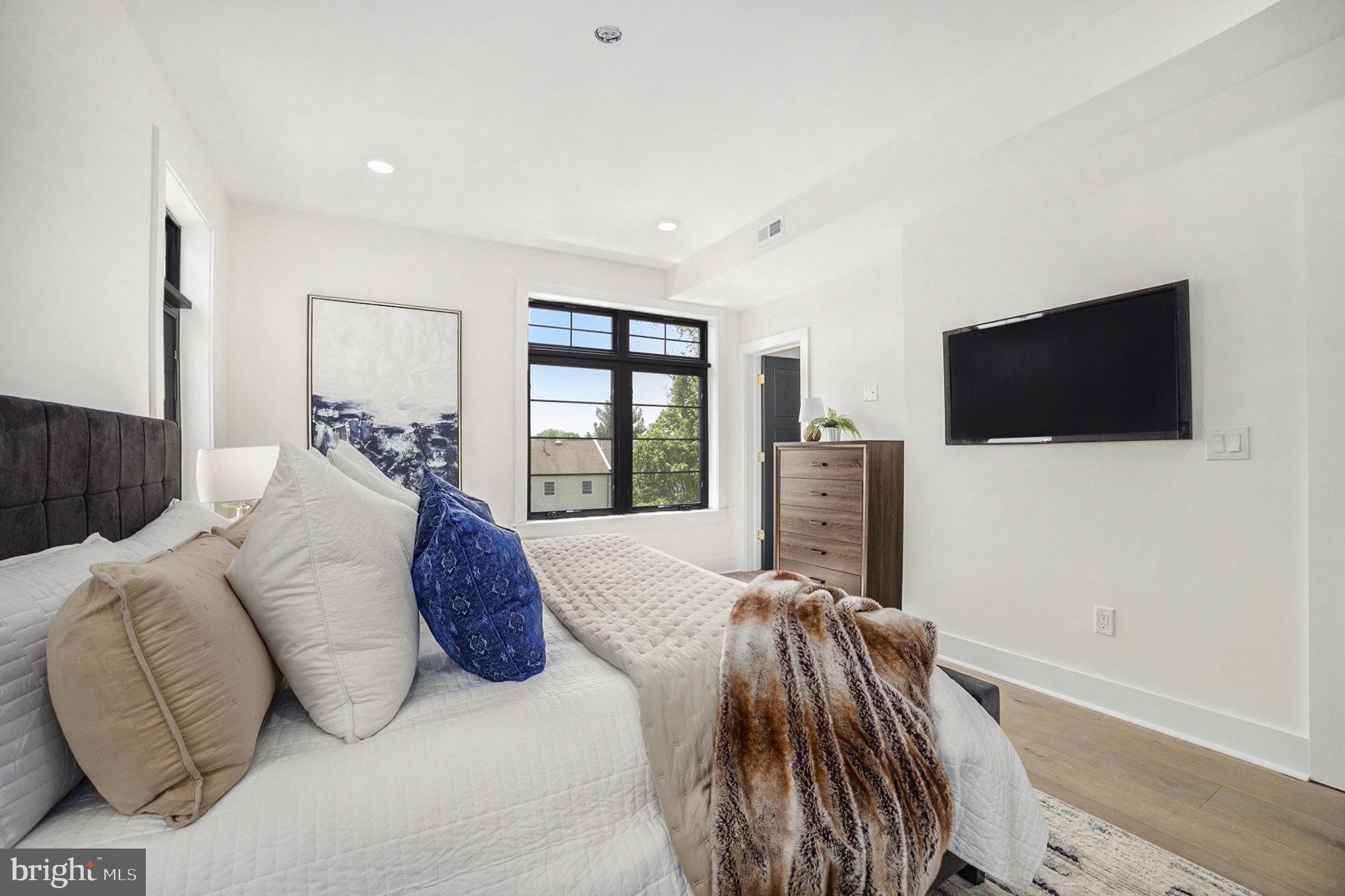 7519 Ridge Avenue, Unit 203 Philadelphia, PA 19128 - Photo 18 of 26 a spacious bedroom with a bed and a flat screen tv