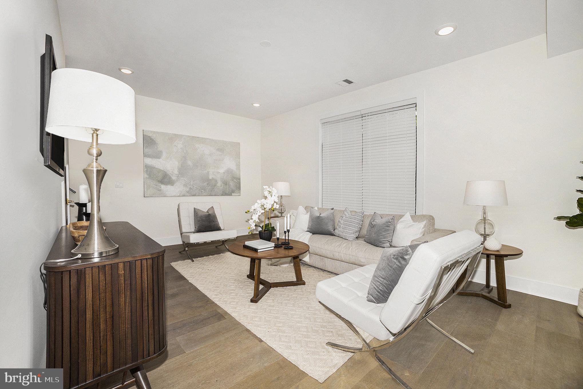 7519 Ridge Avenue, Unit 203 Philadelphia, PA 19128 - Photo 4 of 26 a living room with furniture a rug and a chandelier