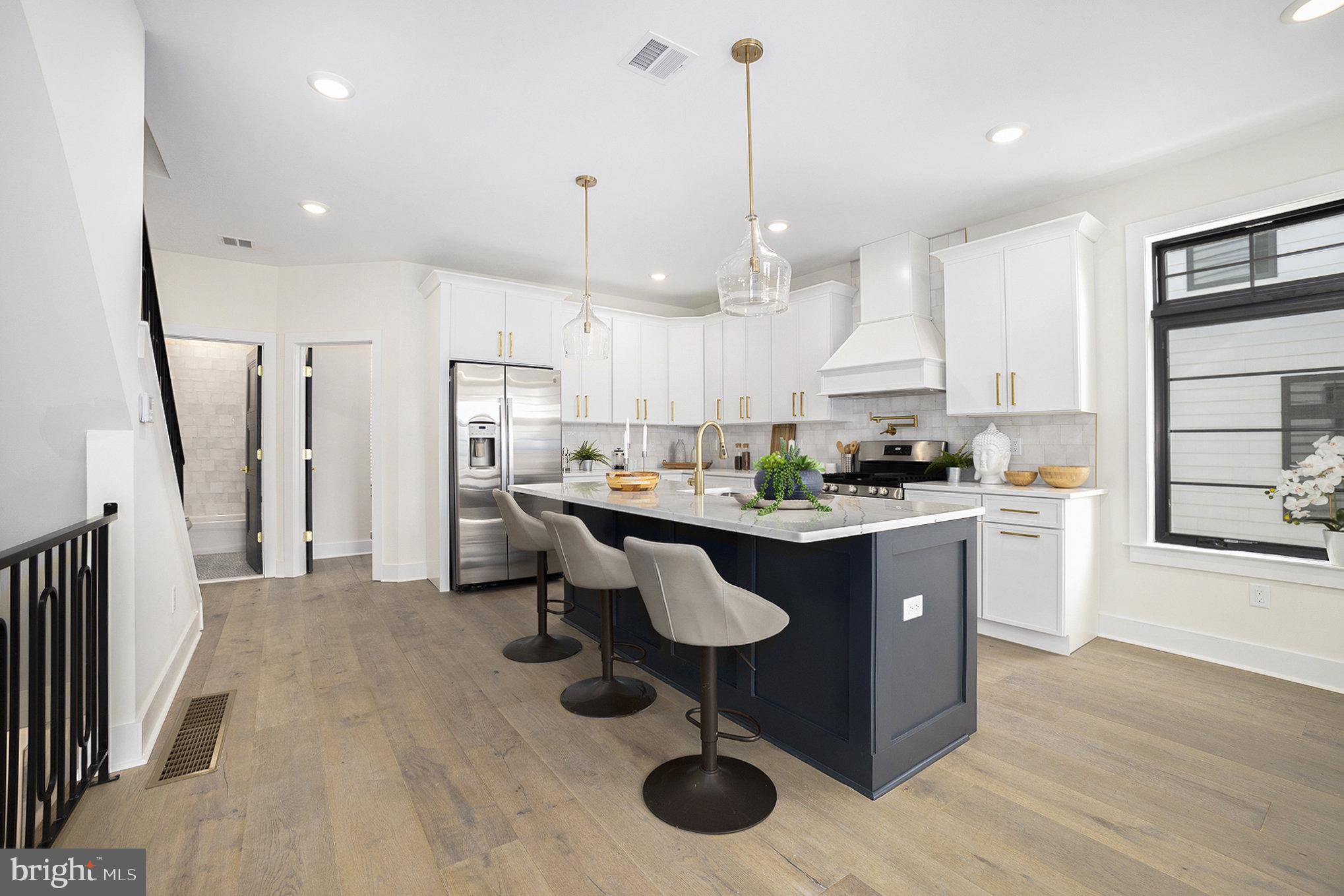 7519 Ridge Avenue, Unit 203 Philadelphia, PA 19128 - Photo 5 of 26 a kitchen with stainless steel appliances kitchen island granite countertop a stove a sink a refrigerator and a wooden cabinets