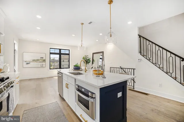 a kitchen with a sink appliances and a wooden floor