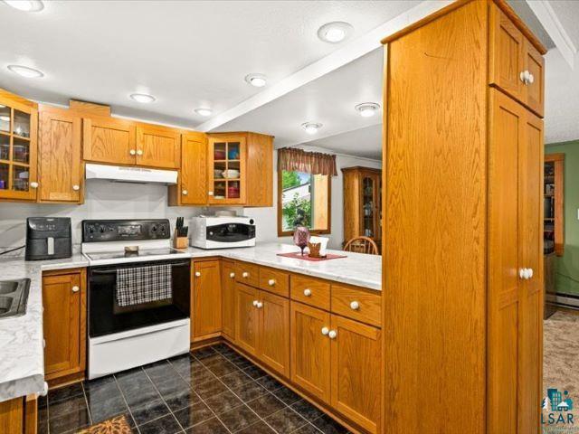 3616 Lavaque Road Hermantown, MN 55811 - Photo 40 of 43 Kitchen featuring ample wood cabinetry, a white electric range, and a corner sink