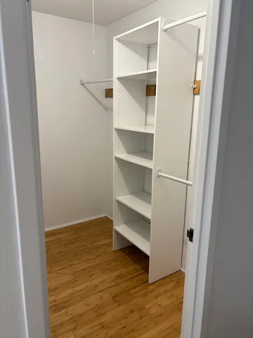 a view of walk in closet with empty racks