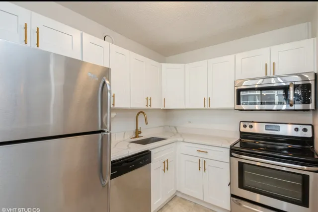 a kitchen with stainless steel appliances a refrigerator sink and cabinets