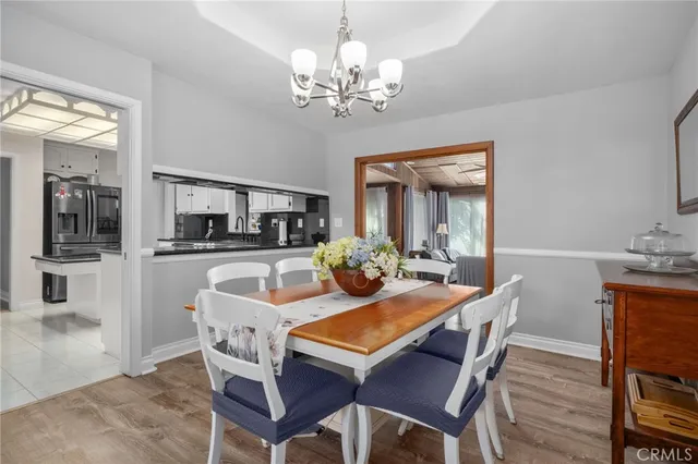 a view of a dining room with furniture a chandelier and wooden floor