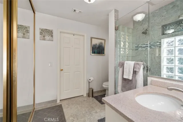 a spacious bathroom with a granite countertop sink a toilet and shower