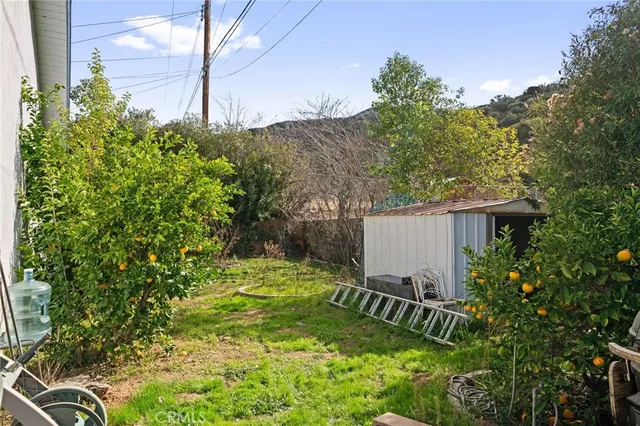 a backyard of a house with table and chairs under an umbrella