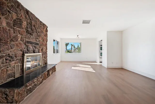 wooden floor in an empty room with a fireplace