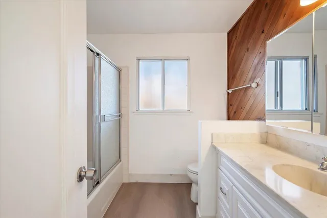a spacious bathroom with a granite countertop sink a mirror and a bathtub