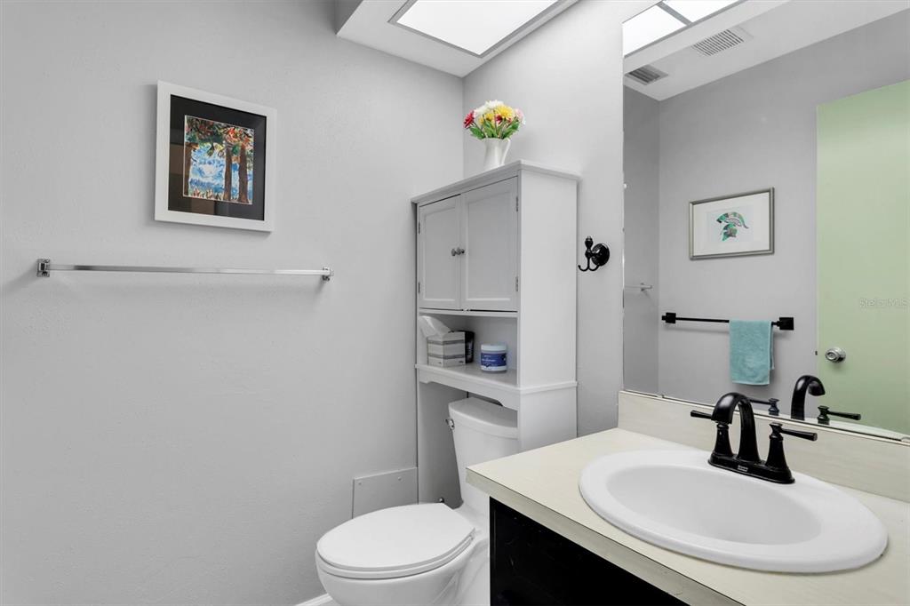 2828 Sherbrooke Lane, Unit C Palm Harbor, FL 34684 - Photo 14 of 40 a bathroom with a toilet a sink and a mirror