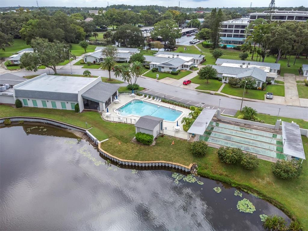 2828 Sherbrooke Lane, Unit C Palm Harbor, FL 34684 - Photo 33 of 40 an aerial view of a house with a garden and lake view
