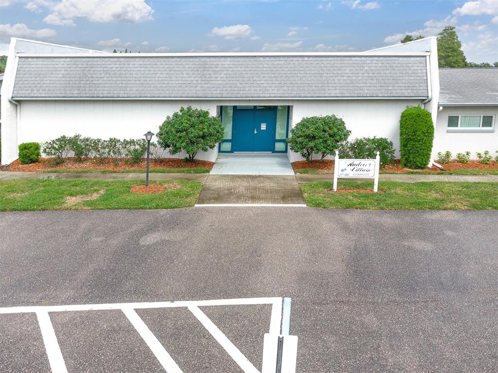 2828 Sherbrooke Lane, Unit C Palm Harbor, FL 34684 - Photo 34 of 40 a front view of a house with a yard and potted plants