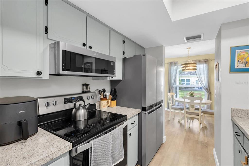 2828 Sherbrooke Lane, Unit C Palm Harbor, FL 34684 - Photo 8 of 40 a kitchen with granite countertop a sink a stove and refrigerator