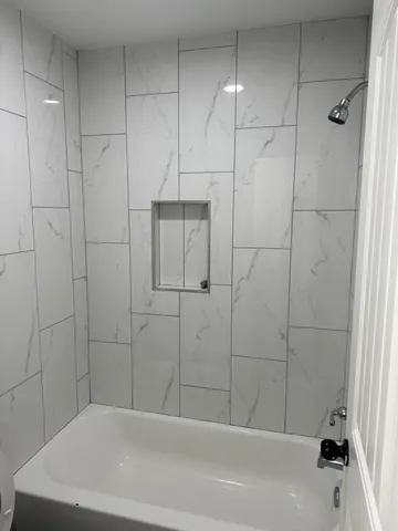 a bathroom with a bathtub and shower