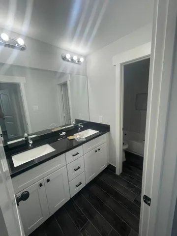 a bathroom with double sink and a mirror