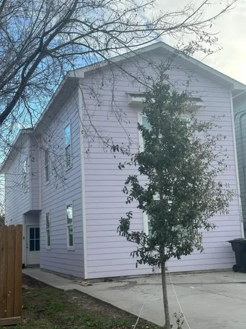 a front view of a house with a tree