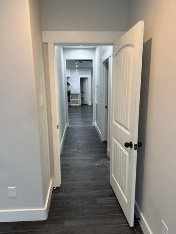 a view of a hallway with wooden floor and staircase