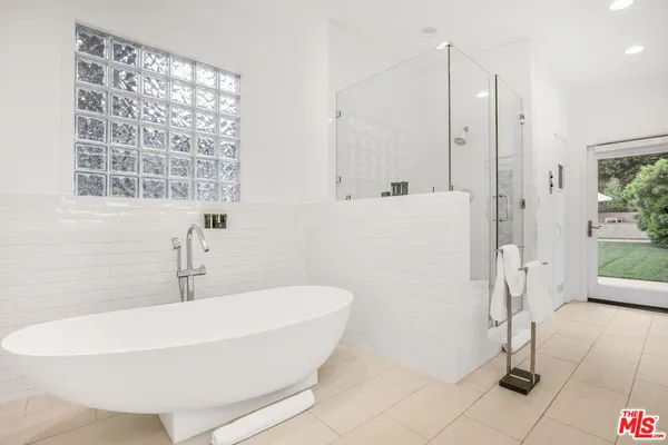 a white bath tub sitting next to a shower