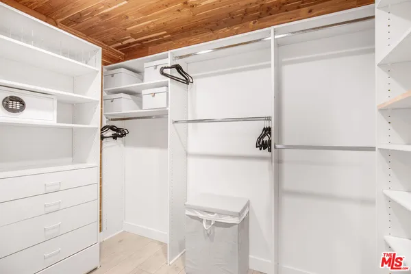 a view of walk in closet with empty racks