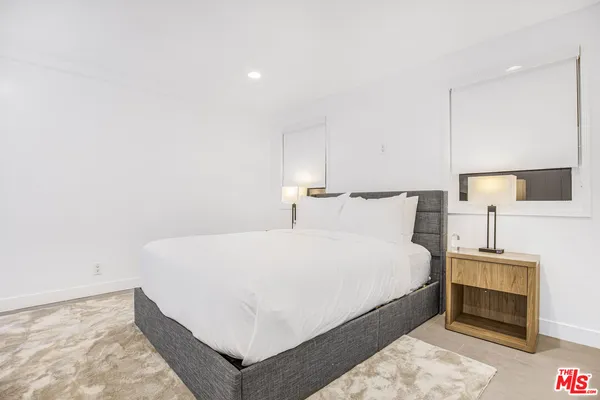 a large bed sitting in a bedroom next to a lamp