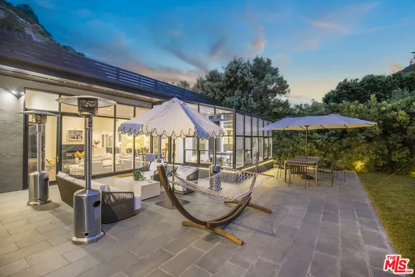 a view of a patio with table and chairs potted plants with wooden floor and fence