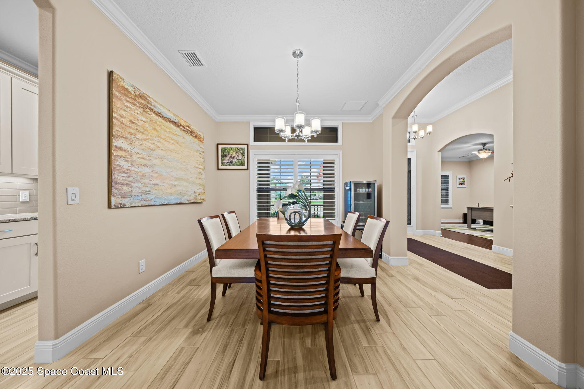 2803 Agilny Lane Melbourne, FL 32940 - Photo 17 of 65 a dining room with furniture a chandelier and wooden floor
