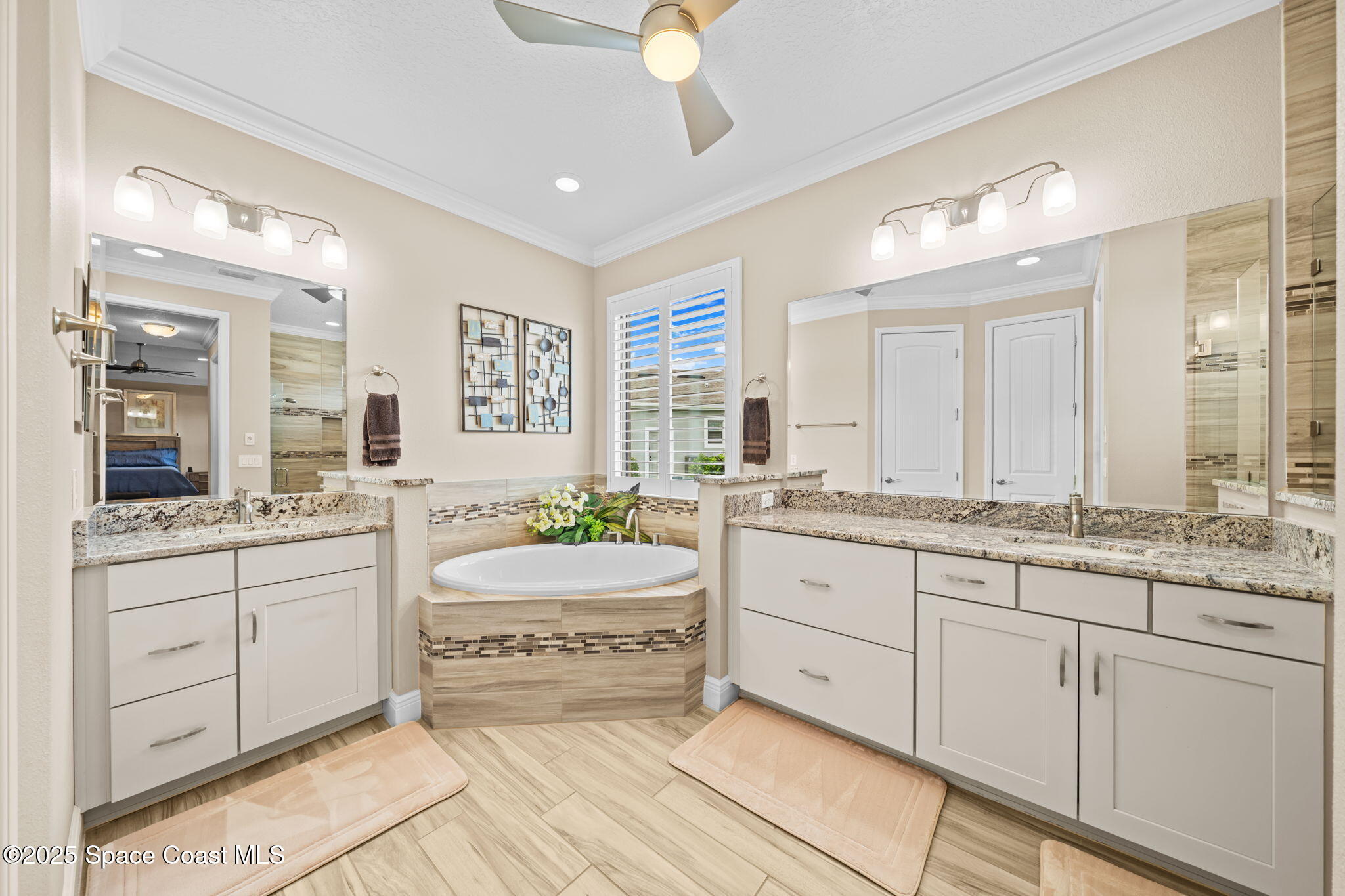 2803 Agilny Lane Melbourne, FL 32940 - Photo 31 of 65 a spacious bathroom with a granite countertop double vanity sink a mirror and a bathtub