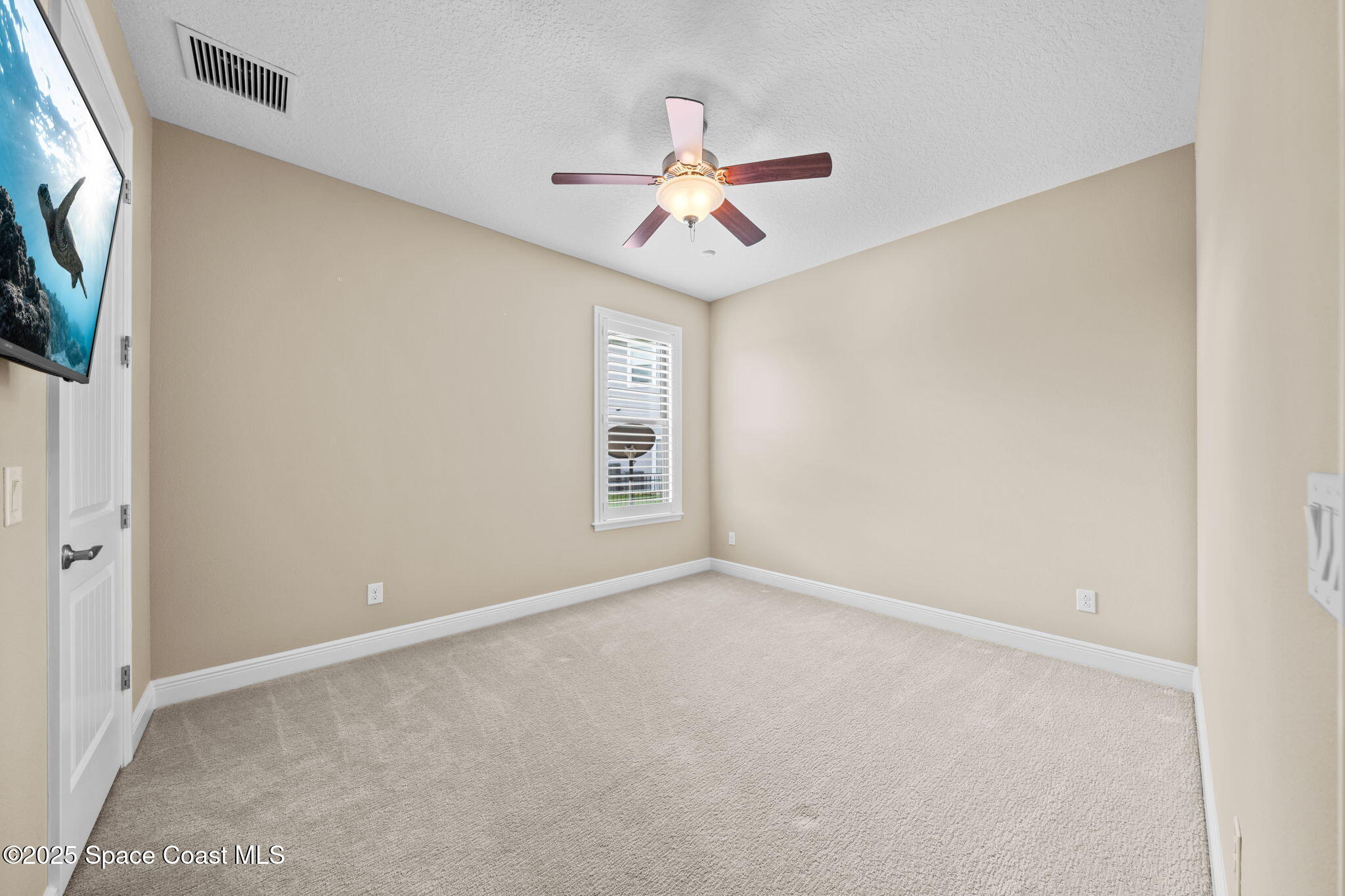 2803 Agilny Lane Melbourne, FL 32940 - Photo 40 of 65 an empty room with windows and fan