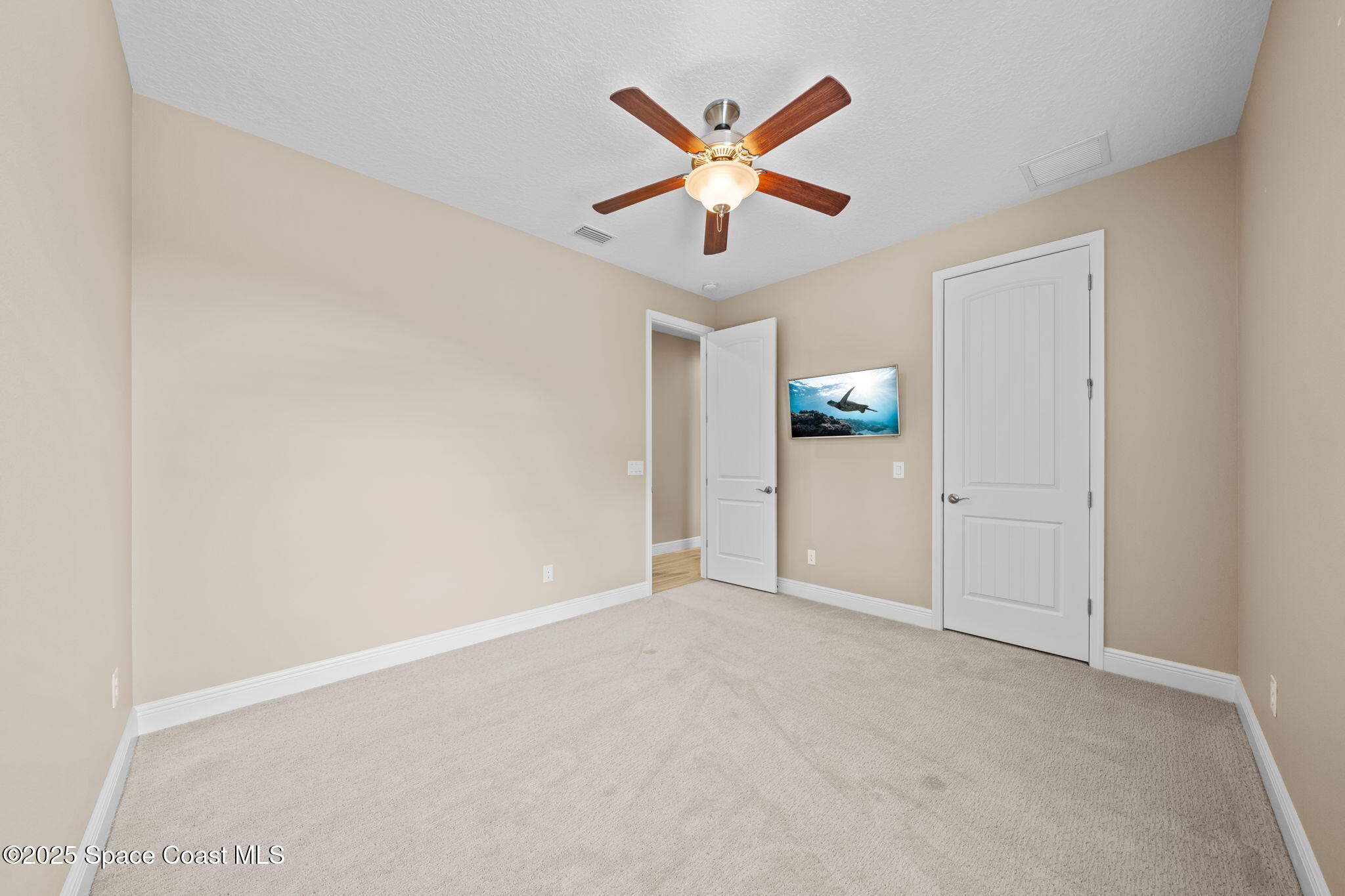 2803 Agilny Lane Melbourne, FL 32940 - Photo 41 of 65 an empty room with ceiling fan and windows
