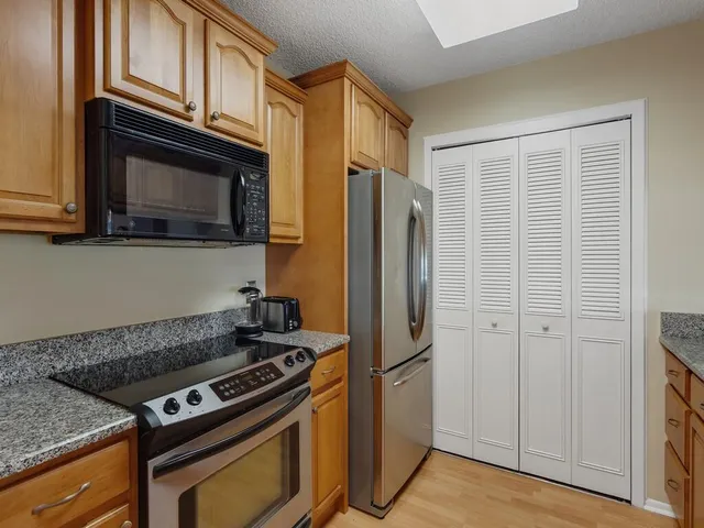 a kitchen with stainless steel appliances granite countertop a refrigerator and a stove top oven