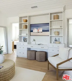 a living room with white cabinets and a table