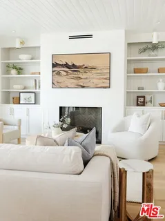 a living room with furniture and a painting on the wall